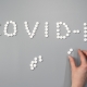 Pills spelling out COVID-19