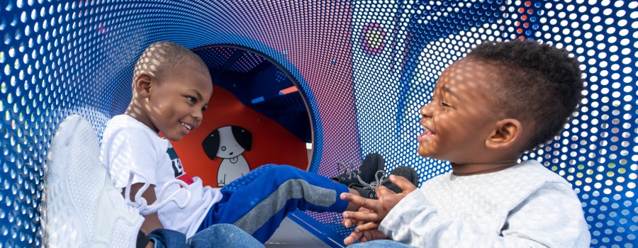 Two young boys socializing in a play tunnel