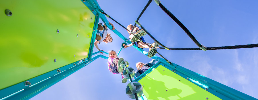 Children ringing the bell at the top of Miracle's Tapered Tower play structure